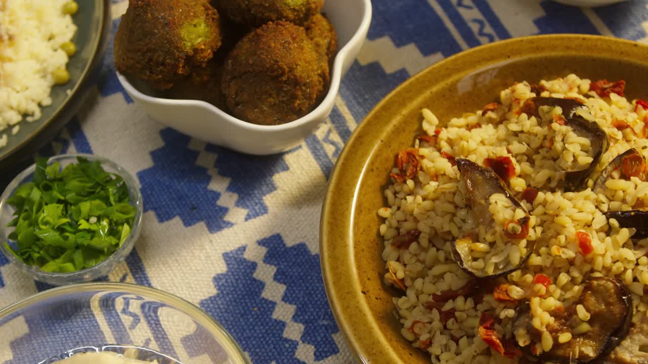 cocina árabe. bulgur con berenjena, falafel, sopa de frijoles en la mesa, cuscús con pollo. cultura tradicional de oriente medio. moutabal y ensalada de verduras en cuencos, pita. arroz delicioso con carne