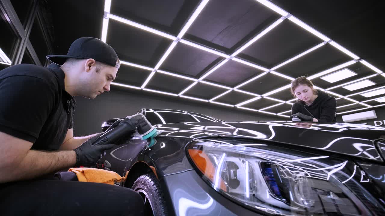 페인트 복원을 위해 기계와 폴리셔를 사용하는 전문 자동차 디테일링.