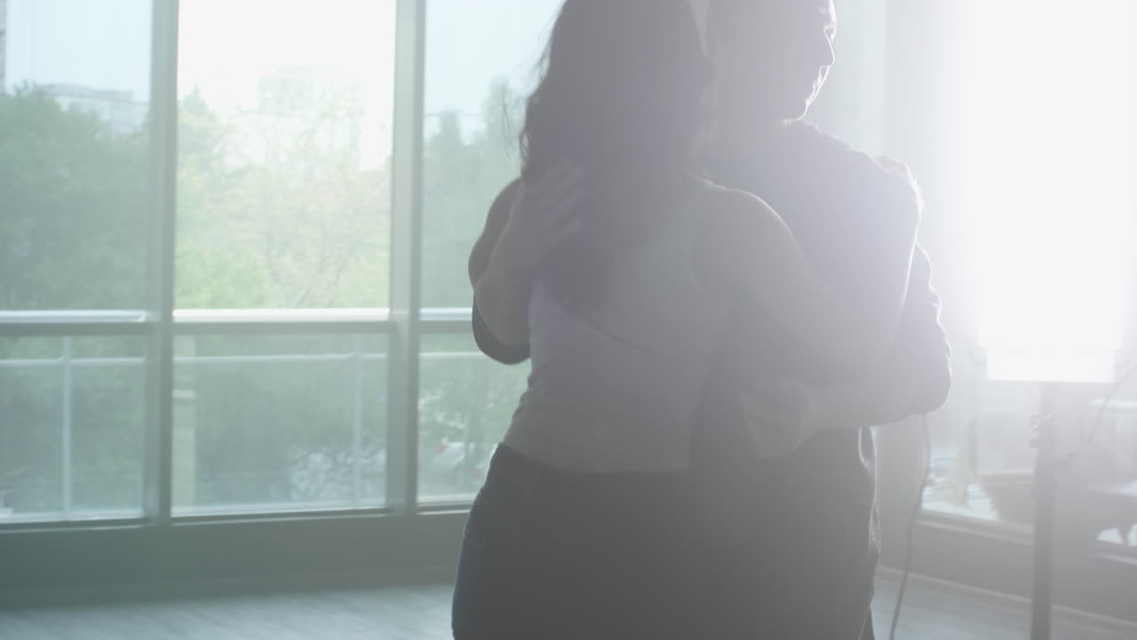 Couple dancing near a window
