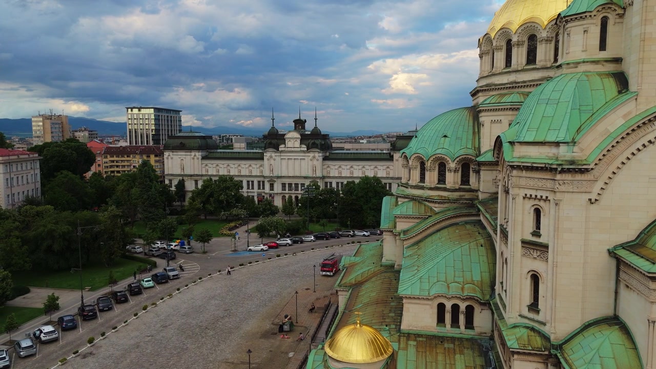 Toma de dron en ángulo bajo encuadrando las cúpulas doradas de la Catedral de Alexander Nevsky en Sofía, Bulgaria. Arquitectura histórica de un hito cristiano ortodoxo a plena luz del día.