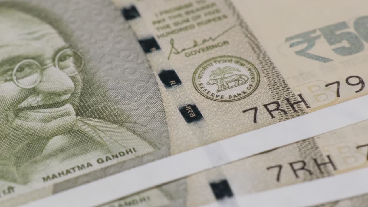 new indian currency arranged in sequence serial number of 500 rupee notes, printed Mahatma Gandhi picture with RBI logo, Security Thread and governor signature. close up shot, pan shot, 4k.