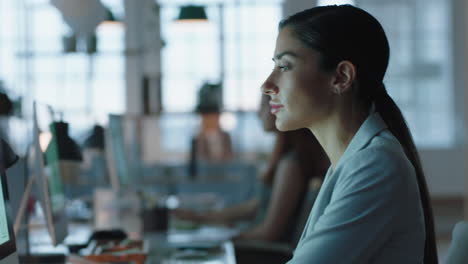 Hermosa-Mujer-De-Negocios-Trabajando-Hasta-Tarde-Usando-Información-De-Navegación-Por-Computadora-En-La-Pantalla-Intercambiando-Ideas-Para-La-Fecha-Límite-Del-Proyecto-En-El-Espacio-De-Trabajo-De-La-Oficina