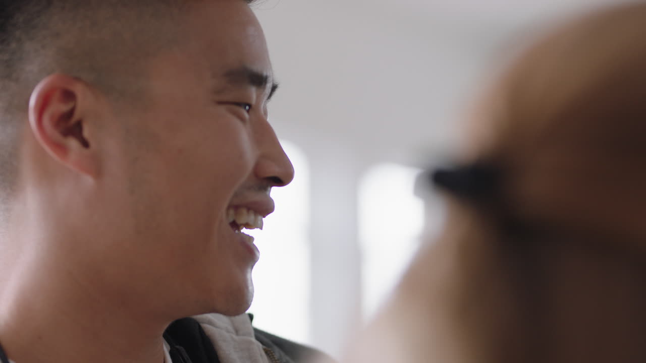 젊은 아시아 사업가 동료들과 채팅하고 미소 짓고 아이디어를 공유하고 사무실에서 팀과 브레인스토밍을 즐기고 있습니다.