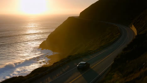 car driving on a scenic coastal road at sunset