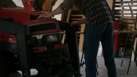 man repairing a tractor in a workshop