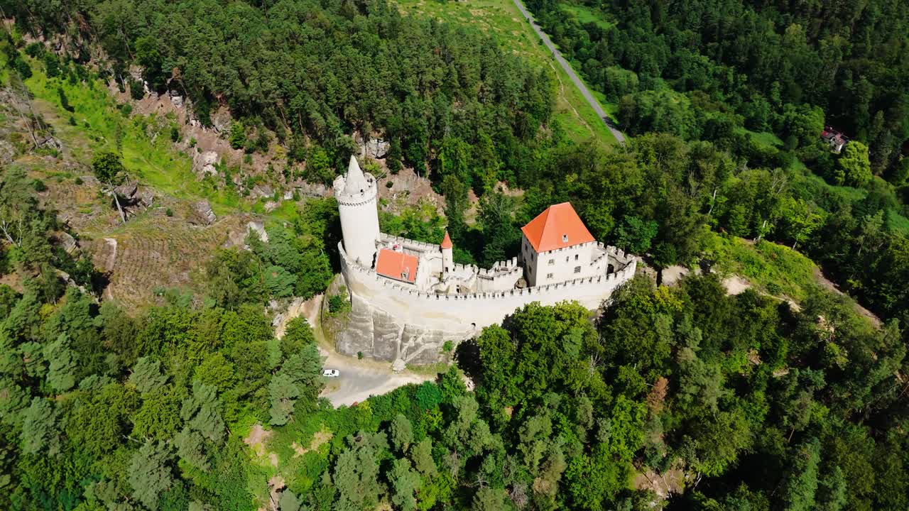 High aerial view over medieval Kokorin castle in rugged terrain, Czechia