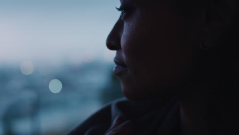 happy young woman looking out window enjoying cold early morning feeling cozy at home