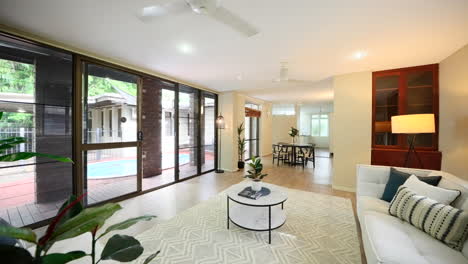 dolly establishes marble coffee table in living room with tropical plantation style decor in open plan with sliding doors