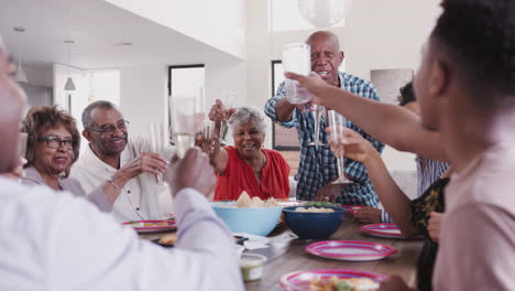 Abuelo-De-Pie-En-La-Mesa-Proponiendo-Un-Brindis-Durante-Una-Celebración-Familiar,-Cerrar