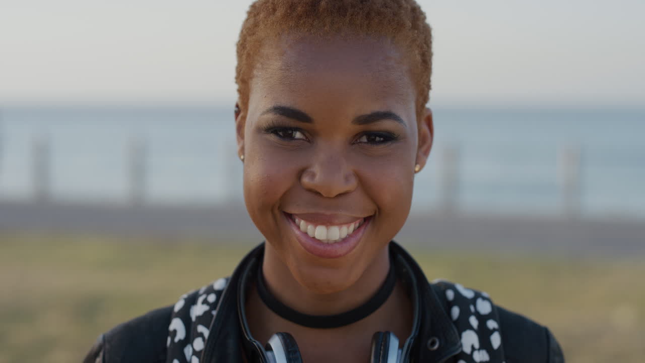retrato de una joven afroamericana con estilo sonriendo disfrutando de un estilo de vida independiente una estudiante negra de moda que parece feliz en la playa frente al mar