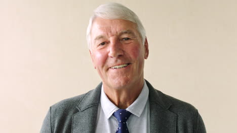 portrait of smiling senior man against a studio