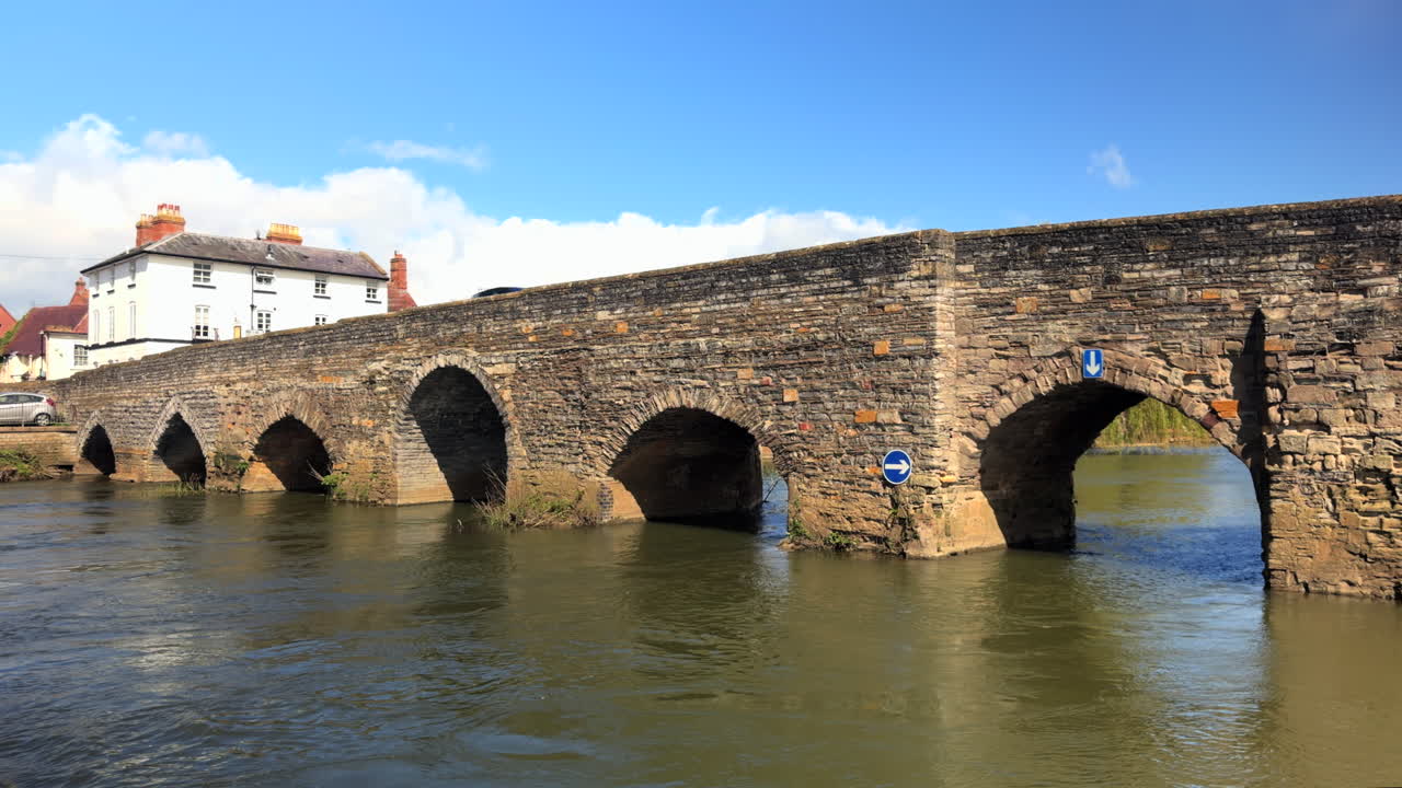 Historic Stone Arch Bridge Over a River with Village Houses