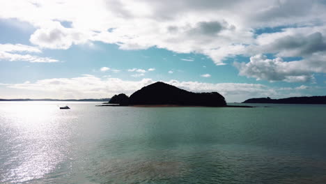 Vista-De-La-Isla-En-Aguas-Prístinas-Bajo-Un-Cielo-Azul-Con-Nubes-Durante-El-Verano-En-Nueva-Zelanda