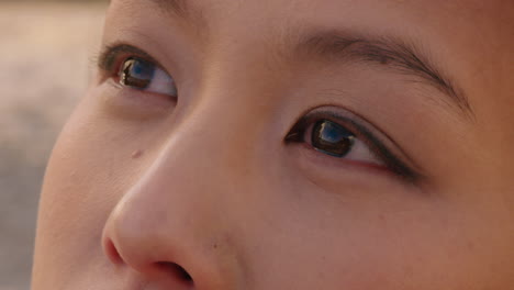 close up portrait of beautiful asian woman enjoying seaside at sunset exploring spirituality looking up praying contemplating journey relaxing on beach