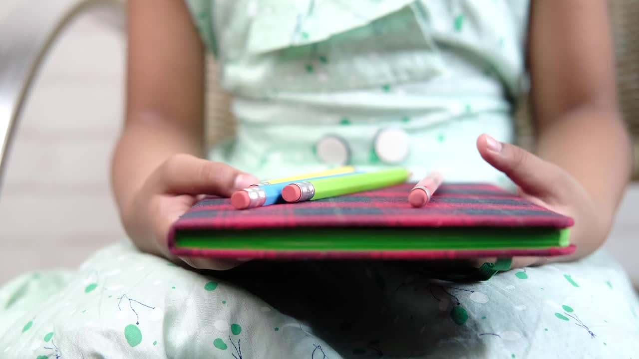 노트북 과 연필 을 들고 있는 아이