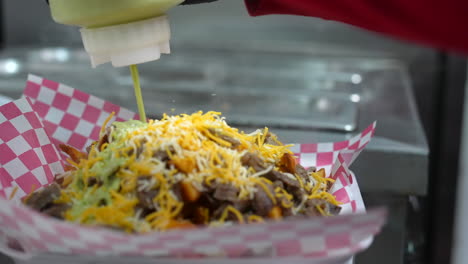 chorros de salsa de guacamole a papas fritas cubiertas con carne asada - serie de camiones de comida