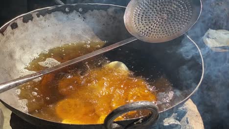 nahaufnahme über bengali luchis, die an einem sonnigen tag in einem stand am straßenrand gebraten werden