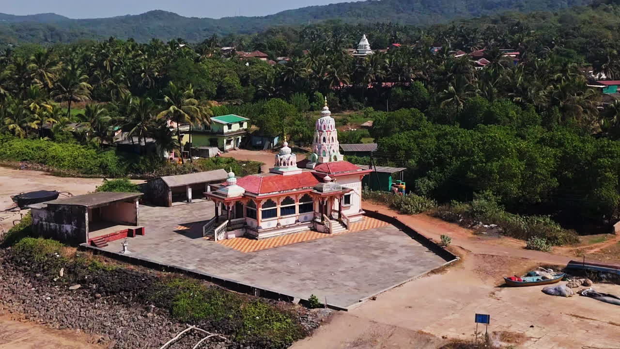 Drone orbiting the Hanuman Mandir Hindu temple, in Guhagar, sunny day in India