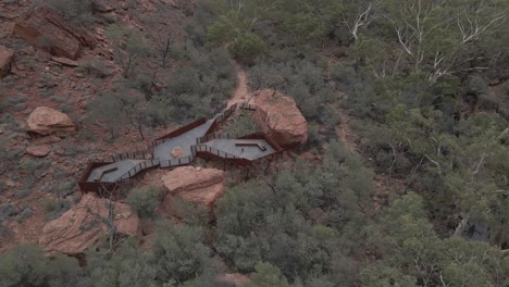 Frau-Winkt-Auf-Aussichtsplattform-Mit-Dicht-Belaubter-Landschaft-Des-Kings-Creek-Walk-In-Petermann,-Australien