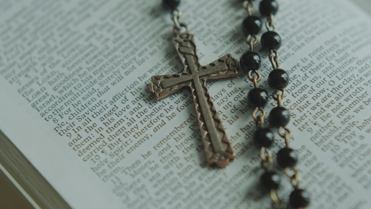 Extreme Close Up of Bible Page with Crucifix Pendant on It