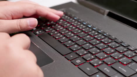 detalle de la mano femenina usando el teclado del portátil