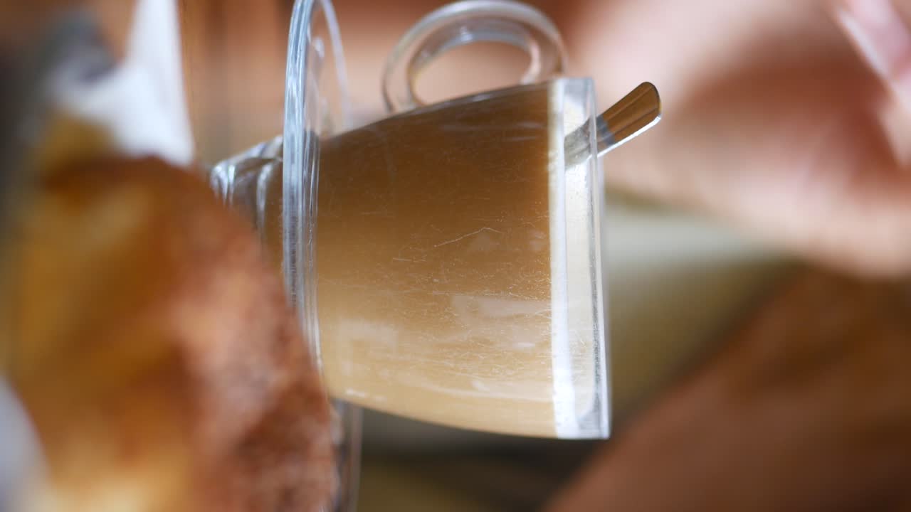 손으로 커피 컵과 페이스트리를 들고