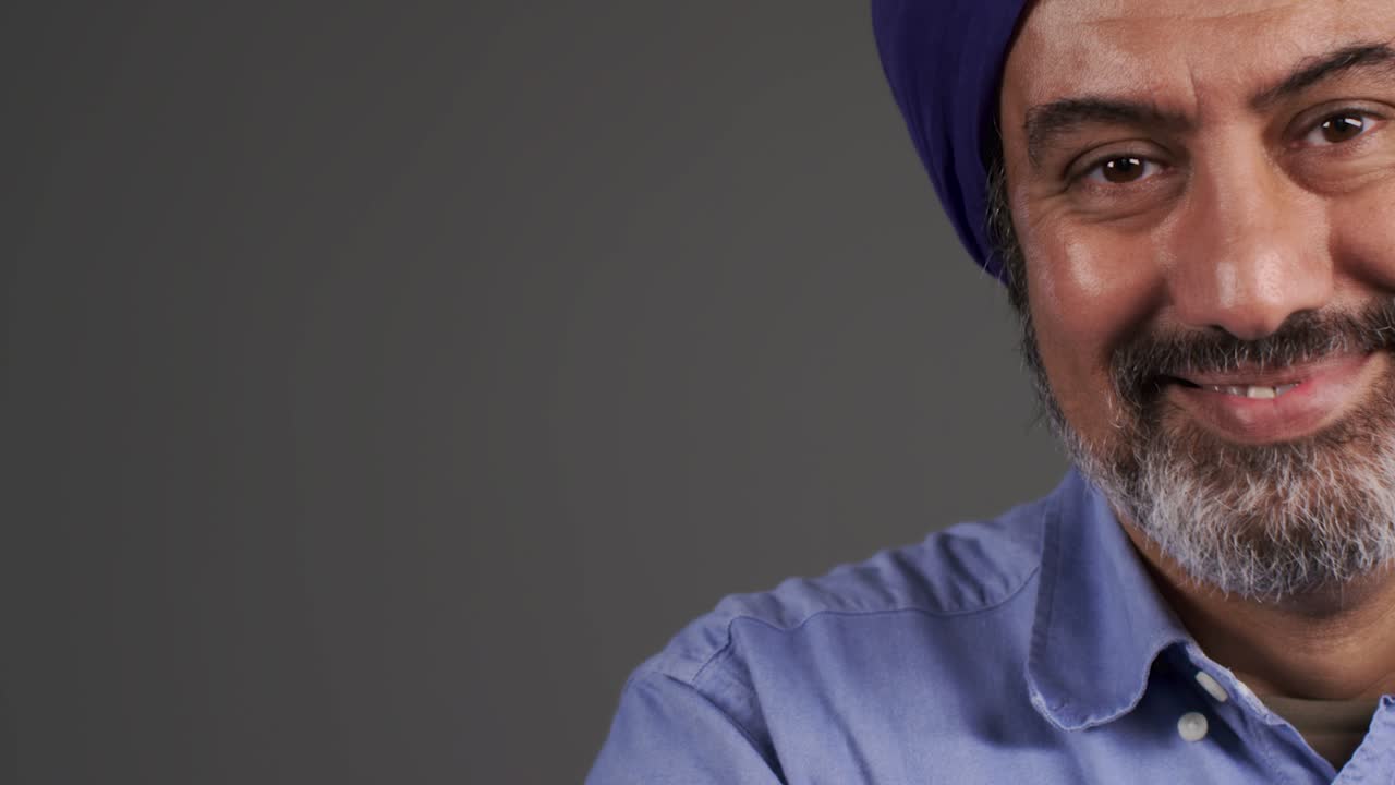 hombre de mediana edad en turbante sonriendo con espacio de copia