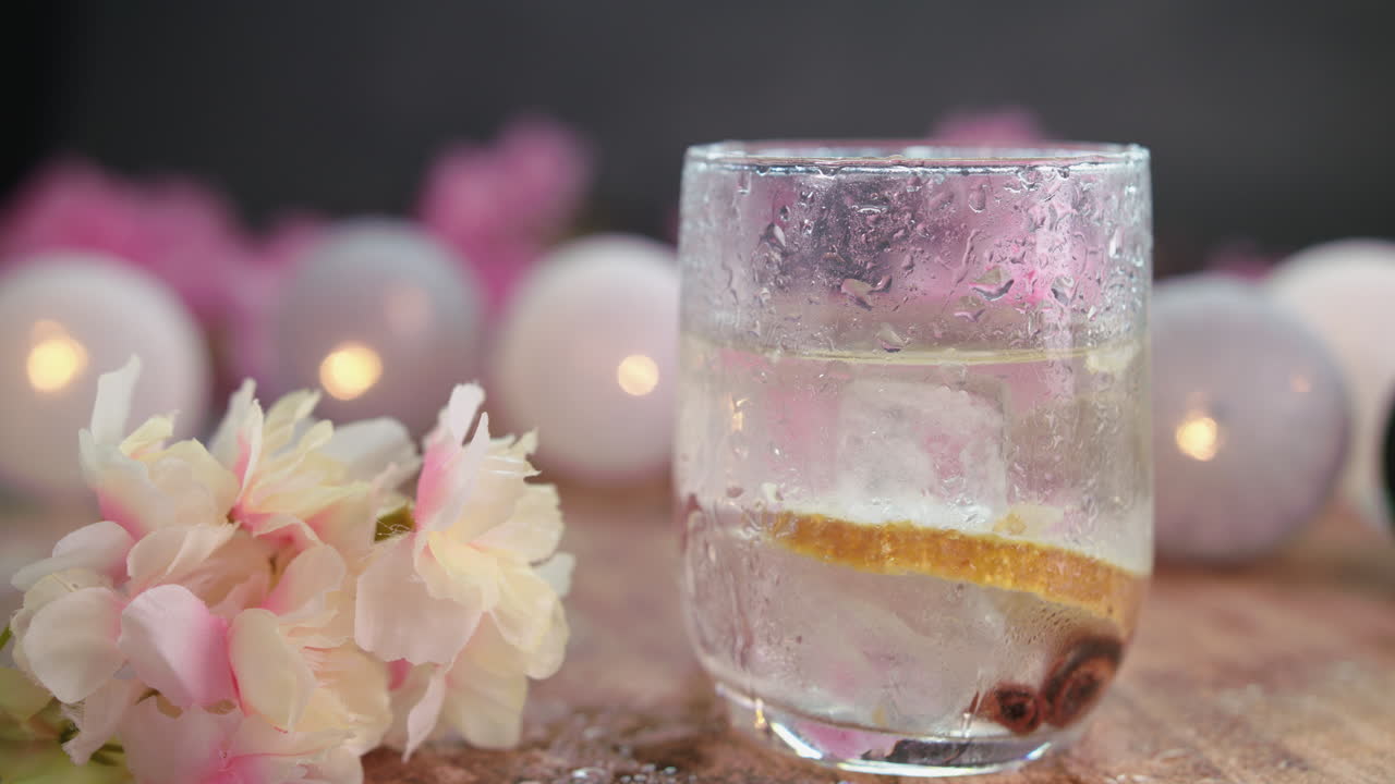 vibrante composición de bar de playa de verano con una bebida tónica, bloques de hielo y una rodaja de naranja