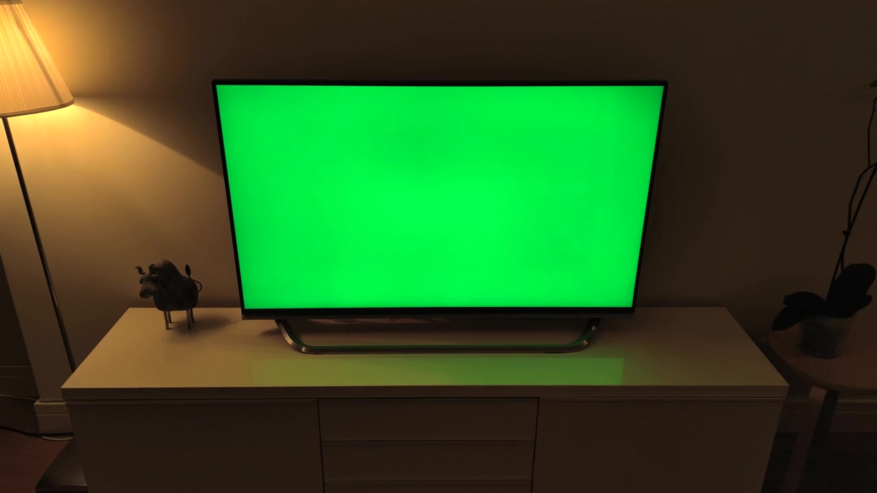 Television with Green Screen Display in Dimly Lit Living Room