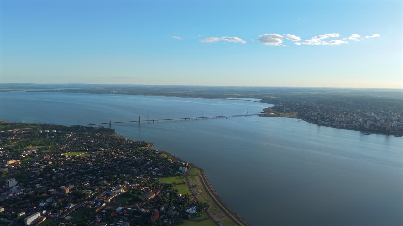 Aerial fly cable stayed bridge connecting Paraguay and Argentina above River landscape, Encarnación and Posadas cities