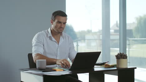 business man working at laptop computer. positive freelancer preparing documents