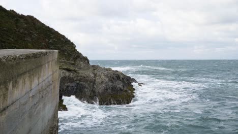 huge waves hit on the rocky shore of newquay harbour in cornwall, england