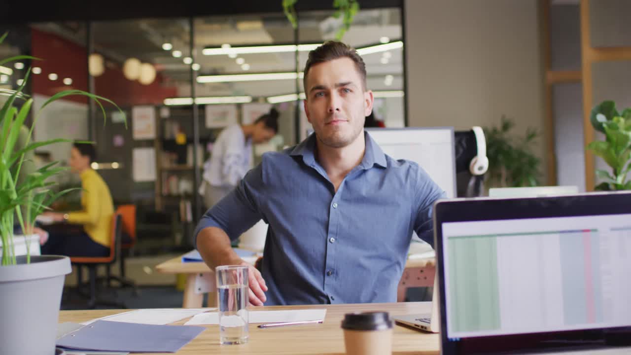 retrato de un feliz hombre de negocios caucásico mirando a la cámara en la oficina