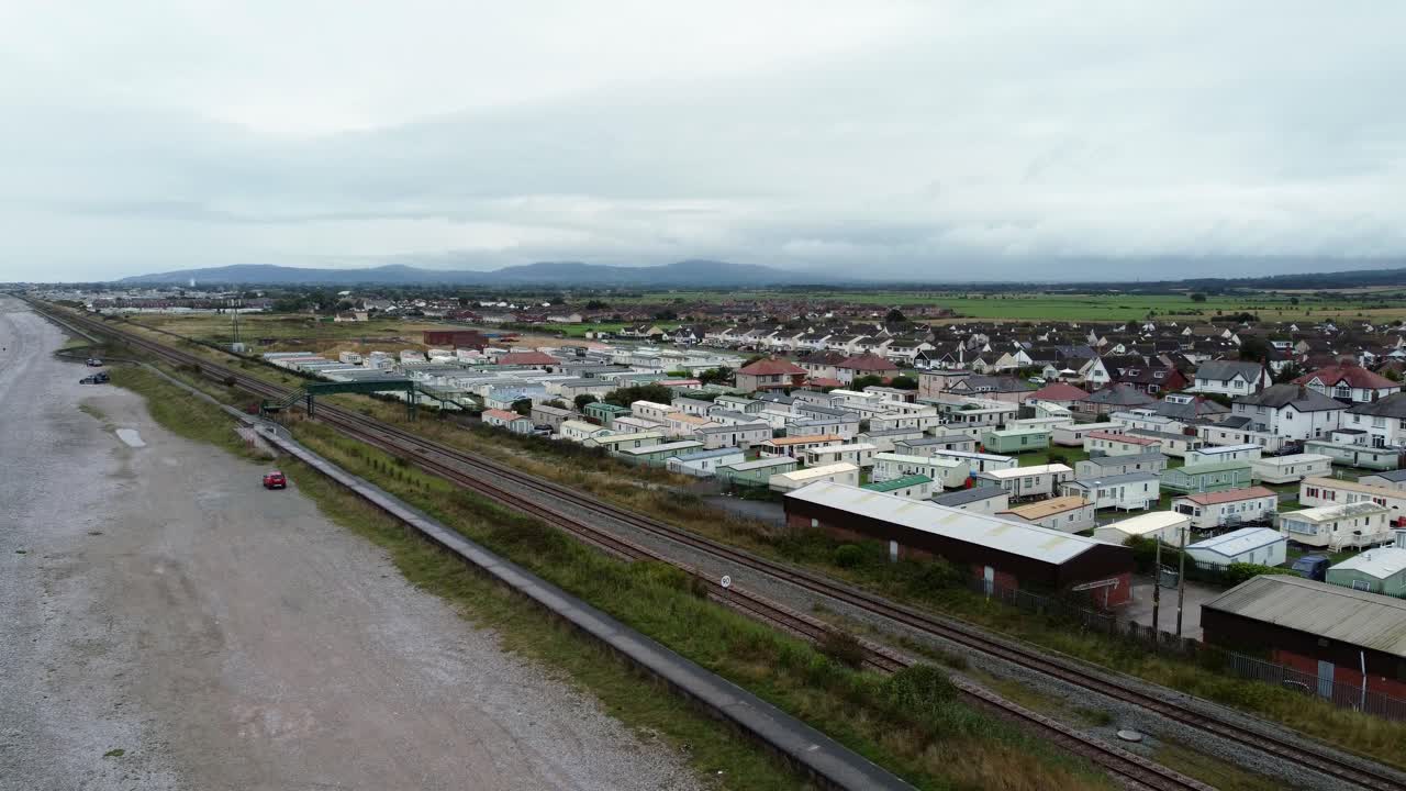 remolque de caravana estática frente a la playa staycation casa de vacaciones camping resort vista aérea elevándose por encima del ferrocarril costero