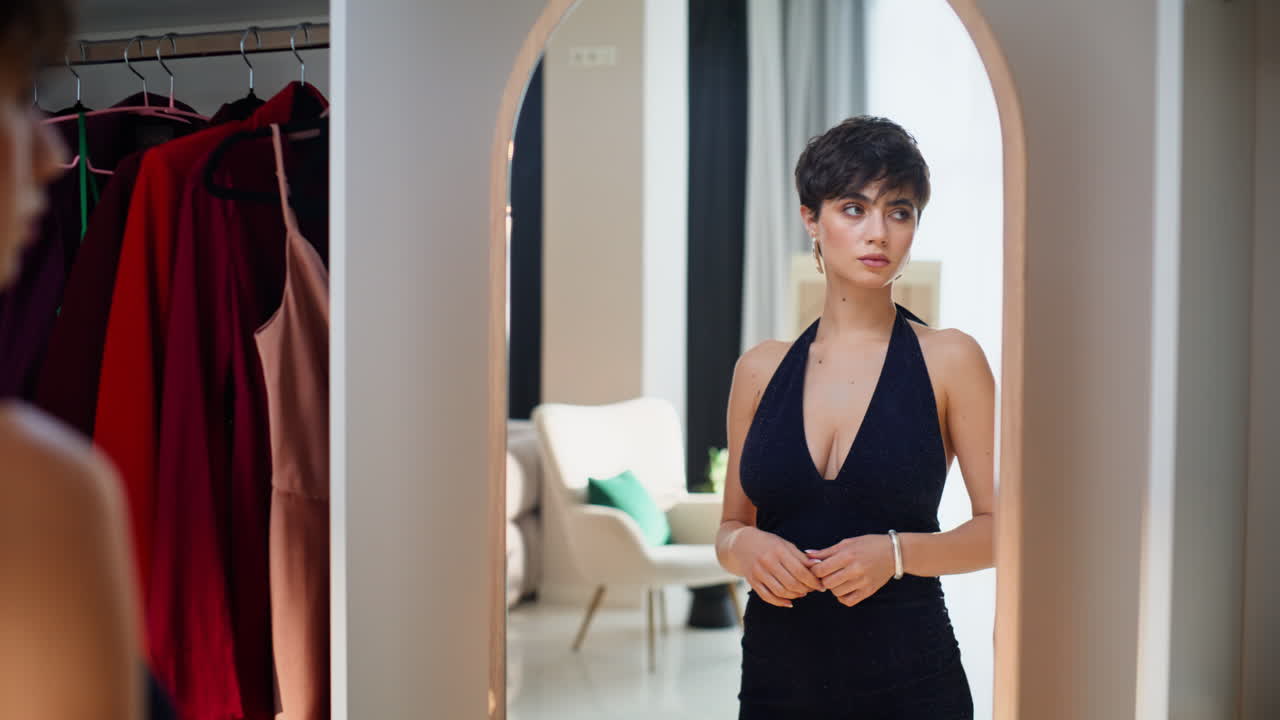 Elegant model looking mirror closeup. Serious gorgeous woman wearing chic dress