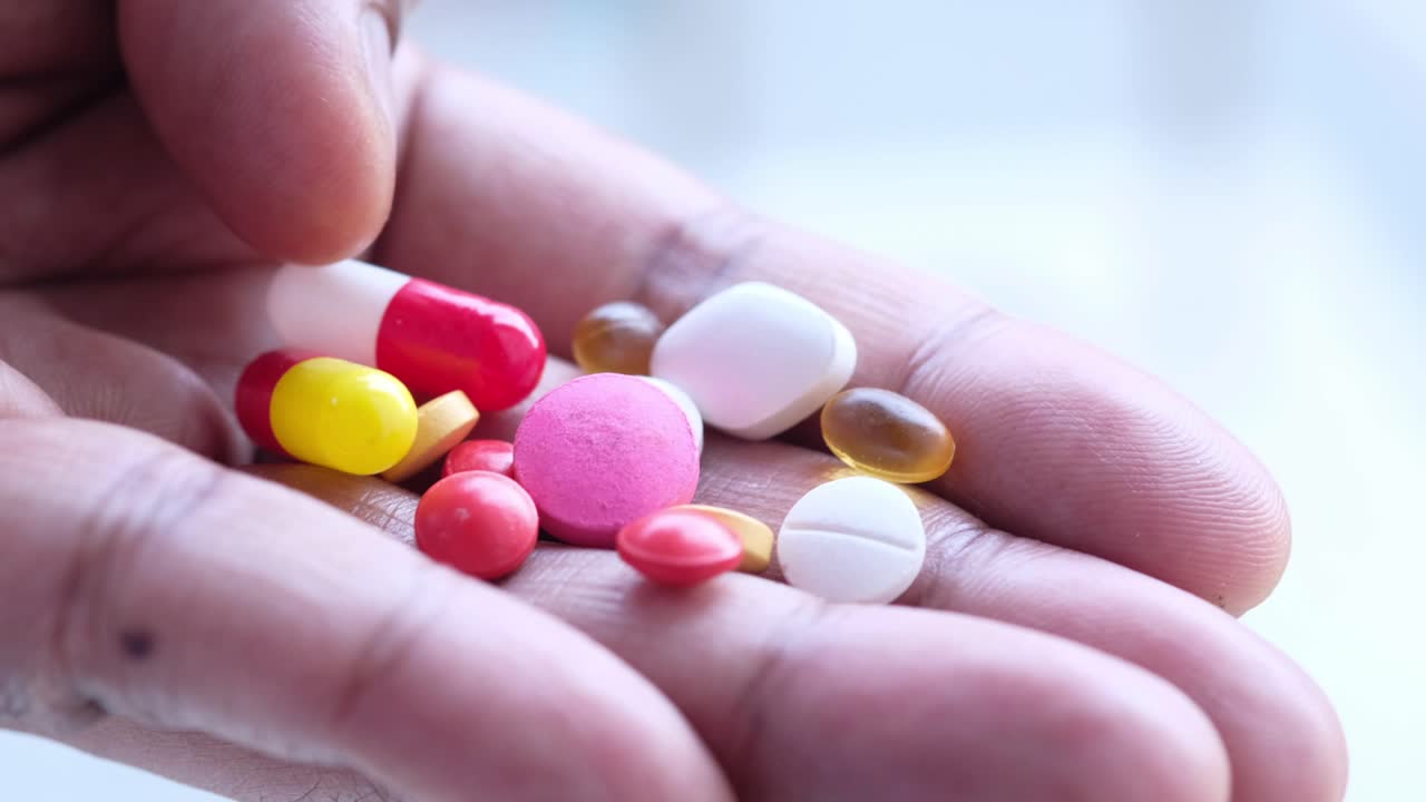 un puñado de pastillas y cápsulas variadas