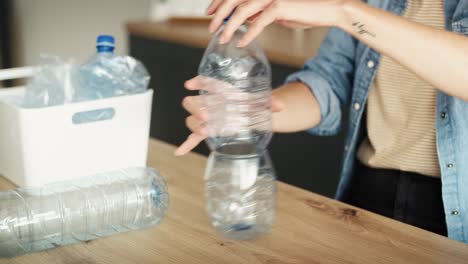 video de una mujer aplastando botellas de plástico