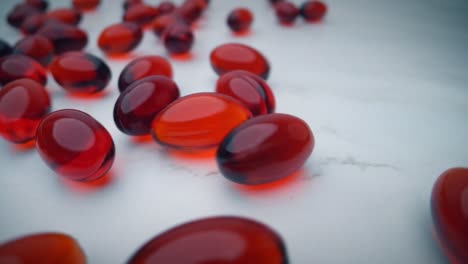 red krill oil capsules bouncing over a white table