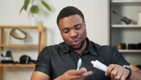 handsome cheerful black man brushing his teeth