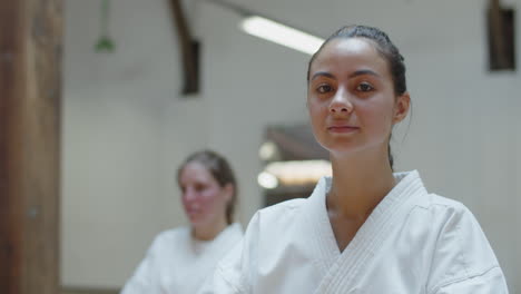 close-up shot of karateka smiling at camera while sitting in gym