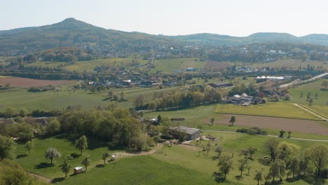 Drone---Aerial-panorama-fly-over-shot-of-a-meadow-with-grass-and-bushes-and-the-Siebengebirge---seven-mountains-in-the-background-25p