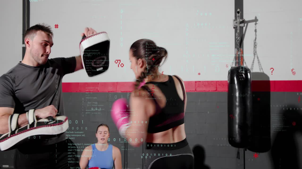 Male trainer shifting focus mitts, female trainee throwing jabs and crosses in boxing training