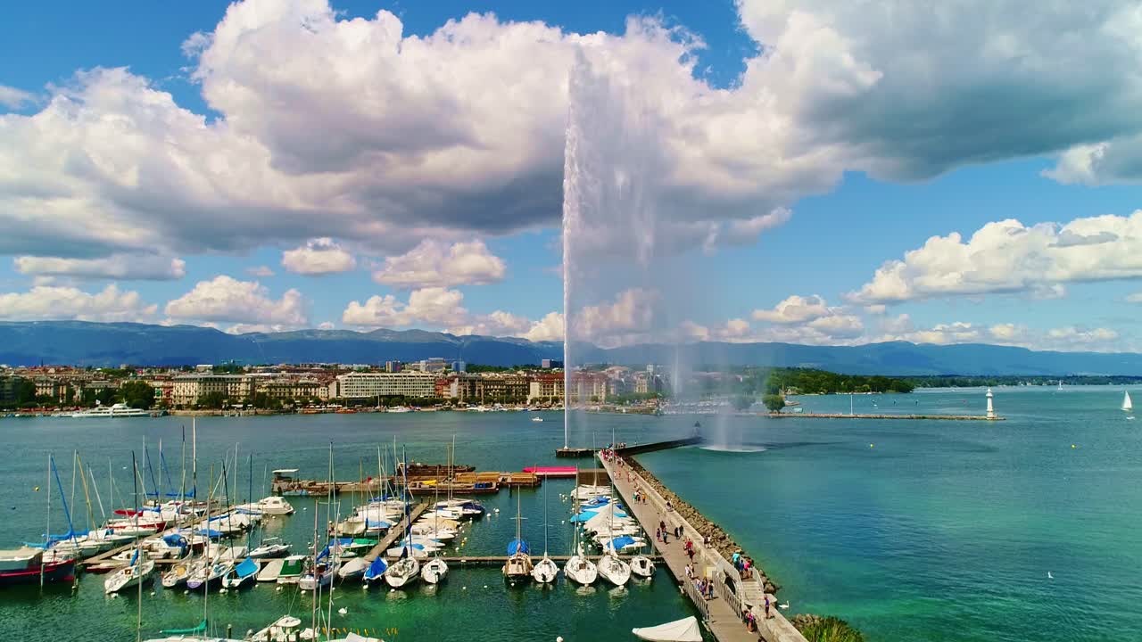 Geneva, Jet d’Eau fountain spraying high into sky, boats and mountains, drone