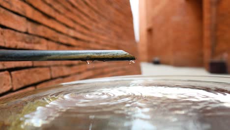 water dripping from pipe creating ripples