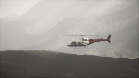 helicóptero volando en cámara lenta extrema cerca de las montañas con niebla