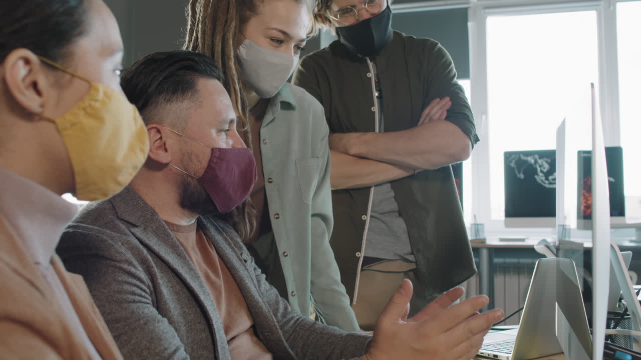 Team of Colleagues in Face Masks Working on Project