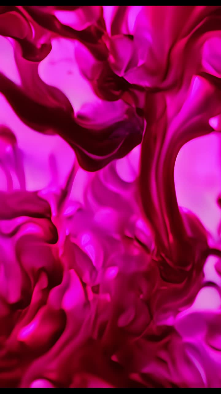 Vertical video: Introducing magenta pigment droplets forming twisting plumes in clear fluid beaker