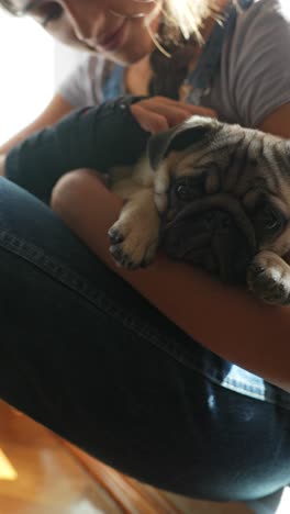 girl holding a pug puppy