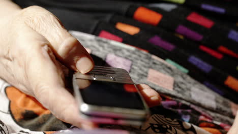 Old-woman-trying-to-dial-a-number-on-her-cell-phone