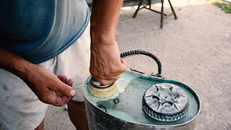 old man fixing things like broken objects in front of his atelier